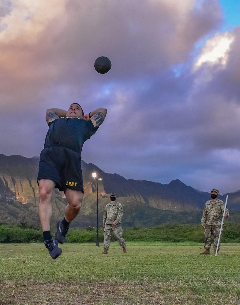 Hawaii Army National Guard Soldier, Chief Warrant Officer 3 Anthony Peck, a UH-60M Black Hawk Helicopter Pilot with Detachment 1, Golf Company, 1st Battalion, 189th Aviation Regiment, 103rd Troop Command gets some air while performing the standing power throw (SPT) event during the Army Combat Fitness Test, Waimanalo, Hawaii, April 2, 2021. The SPT measures upper and lower body explosive power, flexibility, and dynamic balance assisting with tasks like a buddy drag, throwing a hand grenade and employing progressive levels of force in man-to-man contact.
