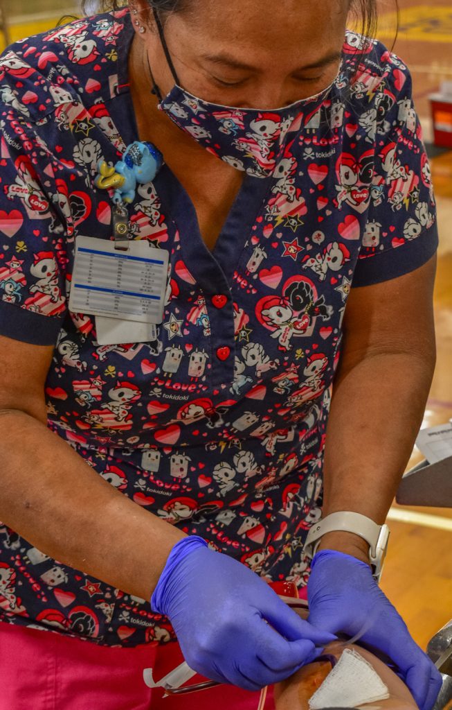 Michele Hanson, a Registered Nurse, explains the plasma donation process to Hawaii Army National Guard (HIARNG) Soldier Capt. Thomas Moriyasu, Executive Officer with the 117th Mobile Public Affairs Detachment during an organized blood drive, Honolulu, Hawaii, June 12, 2021. HIARNG Recruiting and Retention Battalion (RRB) teamed with the Blood Bank of Hawaii and the Hawaii Building and Construction Trades Council to conduct their first of many collaboration efforts scheduled throughout the summer to combat the blood storage deficiency in Hawaii. (U.S. Army National Guard photo by Sgt. 1st Class Theresa Gualdarama)