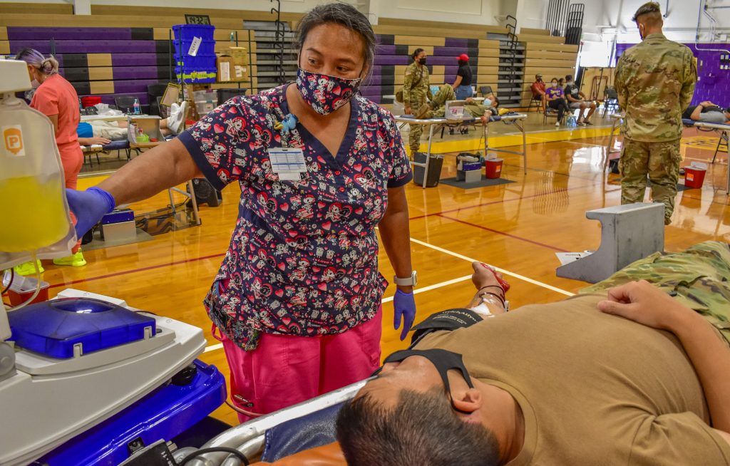Michele Hanson, a Registered Nurse, explains the plasma donation process to Hawaii Army National Guard (HIARNG) Soldier Capt. Thomas Moriyasu, Executive Officer with the 117th Mobile Public Affairs Detachment during an organized blood drive, Honolulu, Hawaii, June 12, 2021. HIARNG Recruiting and Retention Battalion (RRB) teamed with the Blood Bank of Hawaii and the Hawaii Building and Construction Trades Council to conduct their first of many collaboration efforts scheduled throughout the summer to combat the blood storage deficiency in Hawaii. (U.S. Army National Guard photo by Sgt. 1st Class Theresa Gualdarama)