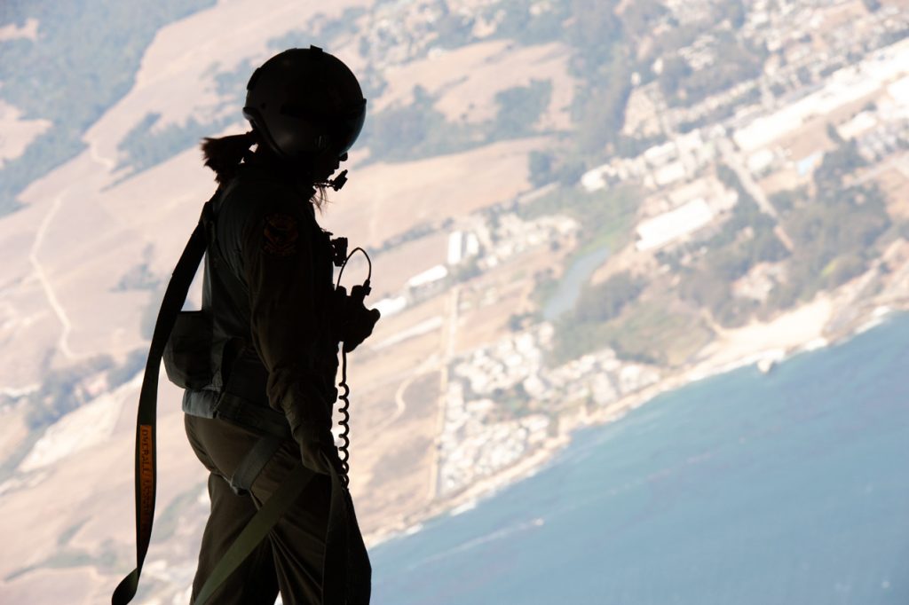 Master Sgt. Joleen Morse, 204th Airlift Squadron loadmaster, prepares to airdrop a rescue craft from a C-17 Globemaster III Sept. 9, 2021, over Santa Cruz Drop Zone, Calif. A Hawaii Air National Guard aircrew flew to California to validate their ability to train alongside Guardian Angel pararescue jumpers from the 131st Rescue Squadron. The combined participants form a Personnel Recovery Task Force that can aid splashed down astronauts far into the Pacific and Atlantic Oceans. (U.S. Air National Guard photo by Staff Sgt. John Linzmeier)