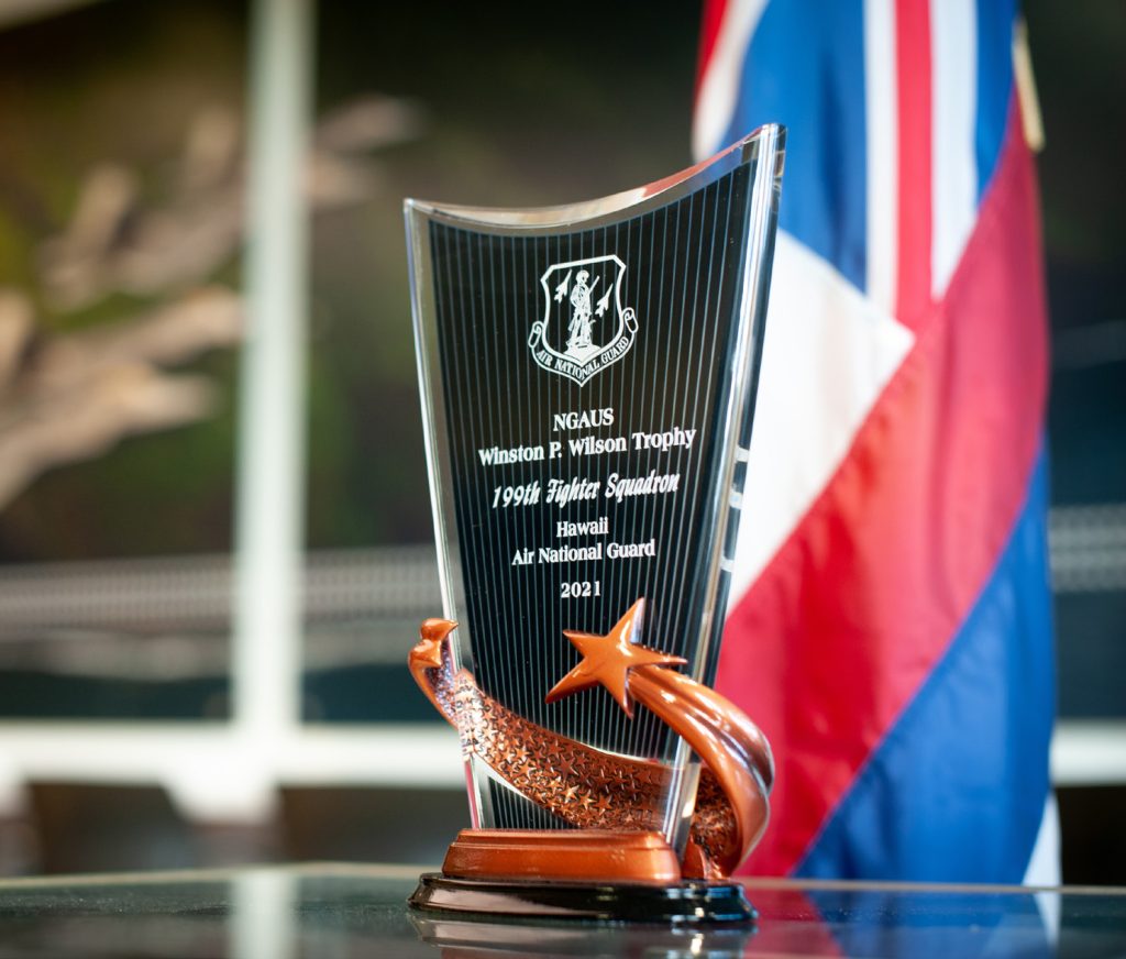 The Winston P. Wilson Trophy for 2021 is displayed at the Hawaii Air National Guard’s 199th Fighter Squadron on Sept. 28, 2021, at Joint Base Pearl Harbor-Hickam, Hawaii. The 199th FS was recognized on behalf of the National Guard Association of the U.S., setting the unit apart from more than 30 other flying squadrons equipped with fighter and reconnaissance aircraft. The trophy is bestowed annually to recognize top performing units, based on overall effectiveness during exercises, deployments, inspection results, accident prevention and many other significant contributions. (U.S. Air National Guard photo by Staff Sgt. John Linzmeier)