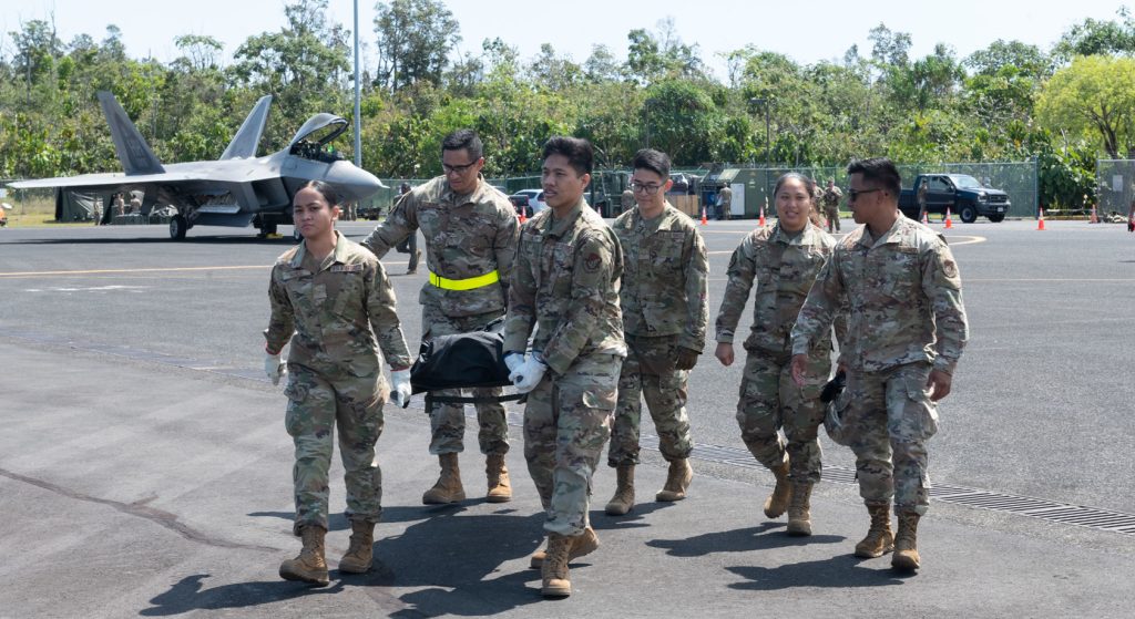 Services Airmen from the 154th Force Support Squadron transport a mannequin during an aero-medical evacuation training scenario during exercise Ho`oikaika March 4, 2022, at Hilo International Airport, Hawai‘i. Exercise participants were challenged to carry out their mission while being exposed to mock scenarios, such as broken equipment, security breaches, and depletion of resources. In addition, wing inspection and inspector general teams observed and evaluated how Airmen perform under adverse and alternative conditions, contributing to a report on how members can improve their best practices. (U.S. Air National Guard photo by Staff Sgt. John Linzmeier)