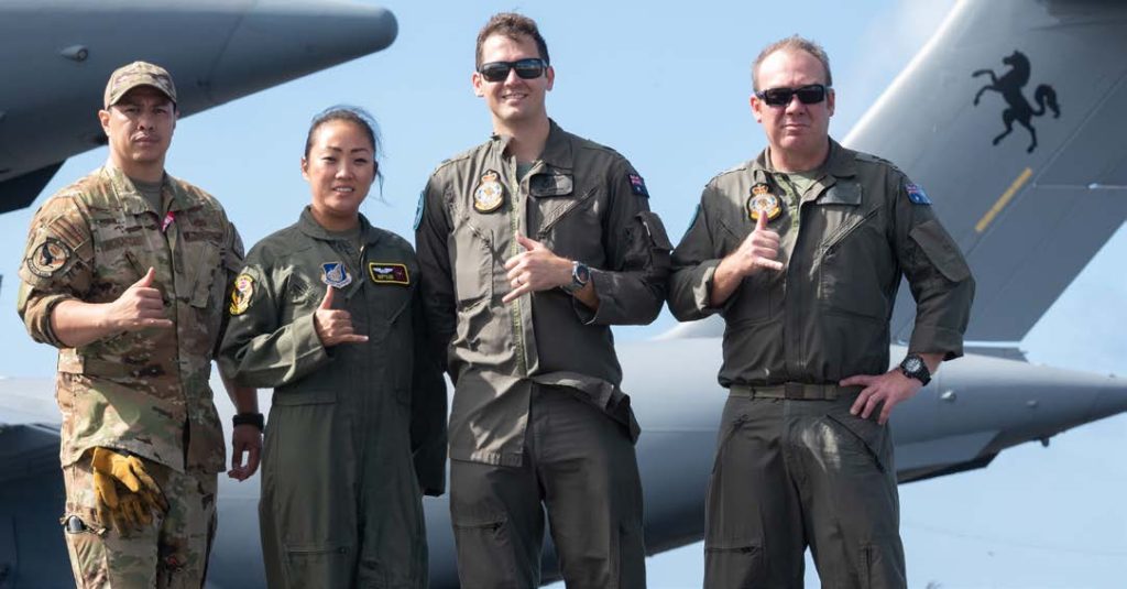 U.S. Air Force loadmasters from the 204th Airlift Squadron, Tech. Sgt. Josh Moracco and Senior Airman Sandra Kim, and Royal Australian Air Force loadmasters from 87 Squadron, Sgt. Ben Russell and Flt Sgt. Jay Johnson, gather May 12, 2022, at Joint Base Pearl Harbor-Hickam, Hawaii. Aircrew members from each nation shared responsibilities on one another’s aircraft throughout training exercise Global Dexterity. The multinational training environment was permitted through an international proclamation known as the ‘Interfly Agreement,’ enabling bilateral crew members to operate together in the same aircraft. (U.S. Air National Guard photo by Staff Sgt. John Linzmeier)