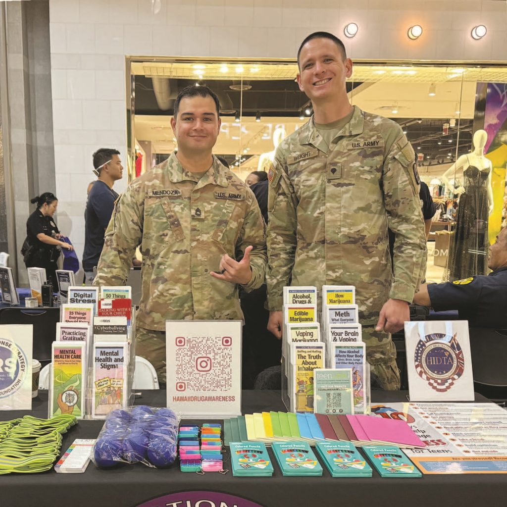 Above, Sgt. 1st Class Waylen Mendoza and Spc. Jantzen Weight of the Hawai‘i National Guard Counterdrug Program conducted drug demand reduction outreach during the “Celebrate Safe Communities” event at Pearlridge Center. They shared information and resources with the community, raising awareness about drug prevention and supporting the mission to keep Hawai‘i safe.” – Staff Sgt. Victoria Schlesinger photo