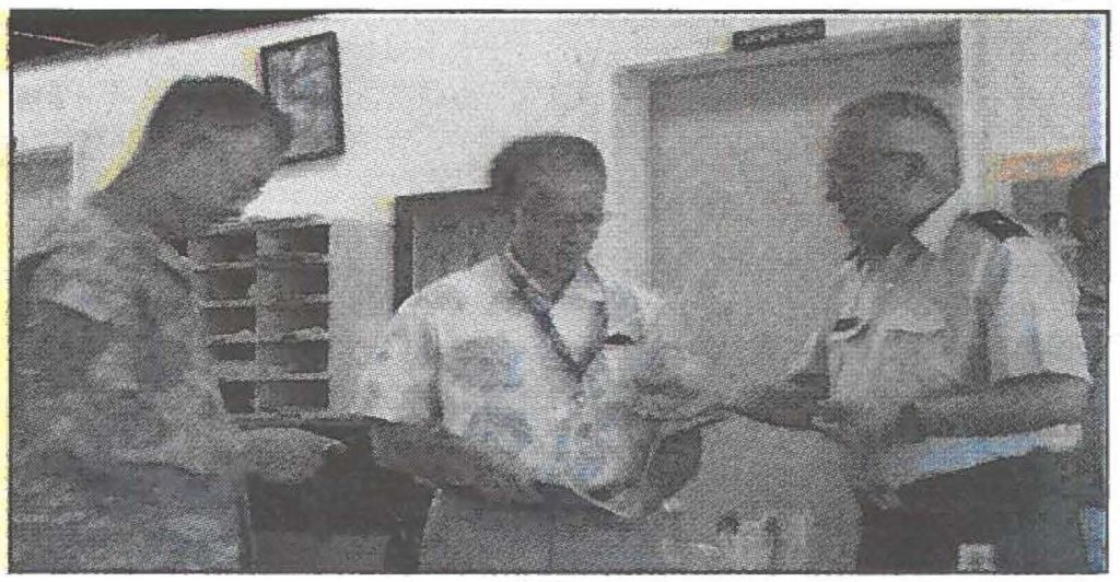 BELOW RIGHT - Brig. Gen. Gary Ishikawa explains the concept behind the 1,000 Shining Stars booklet to Col. (ret) James Townsend. The booklet was published in appreciation of government employees who contributed to the State of Hawaii. Photos by Shelly Ichishita