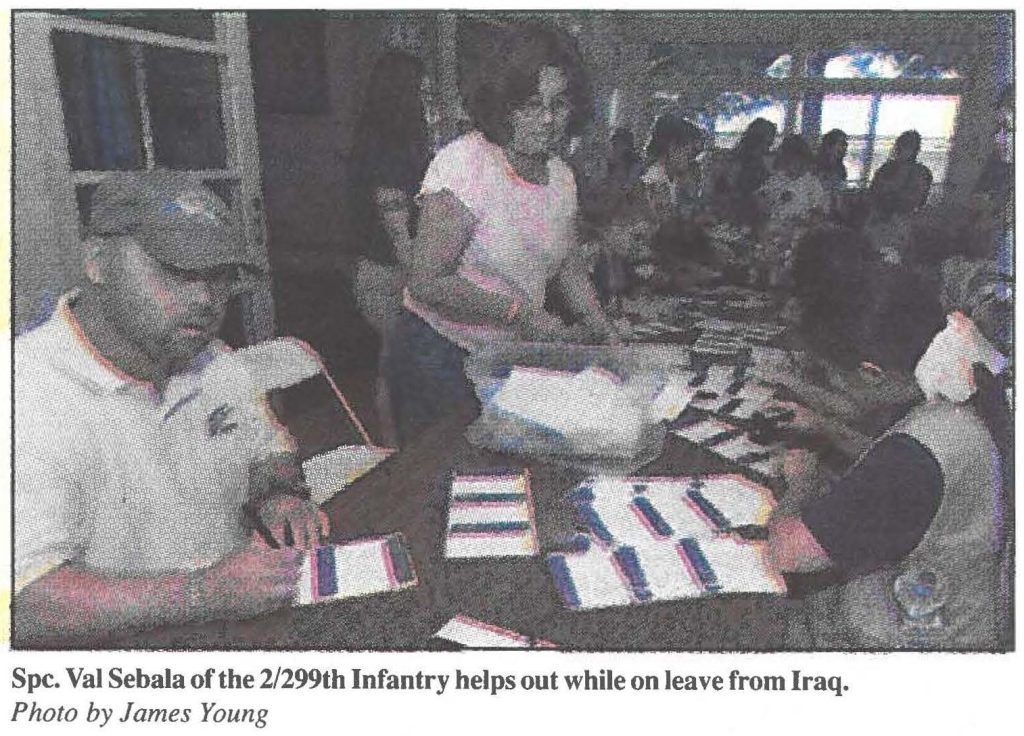 Spc. Val Sebala of the 21299th Infantry helps out while on leave from Iraq. Photo by James Young