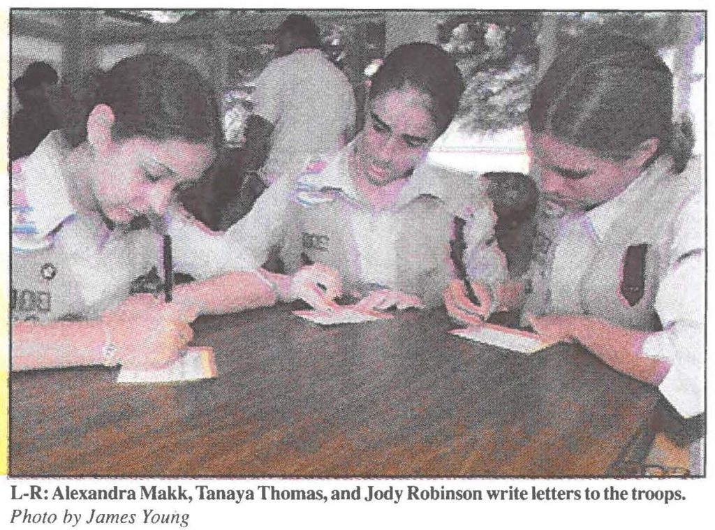 L-R: Alexandra Makk, Tanaya Thomas, and Jody Robinson write letters to the troops. Photo by James Young