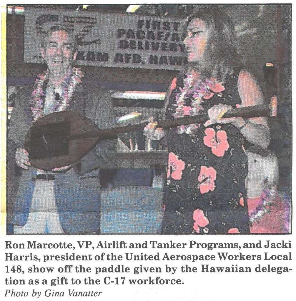 Ron Marcotte, VP, Airlift and Tanker Programs, and Jacki Harris, president of the United Aerospace Workers Local 148, show off the paddle given by the Hawaiian delegation as a gift to the C-17 workforce. Photo by Gina Vanatter