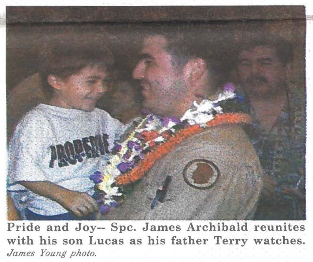 Pride and Joy-- Spc. James Archibald reunites with his son Lucas as his father Terry watches. James Young photo.