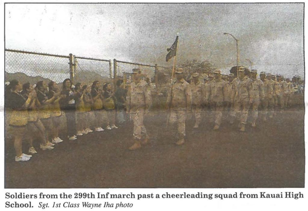 Soldiers from the 299th Inf march past a cheer leading squad from Kauai High School. Sgt. 1st Class Wayne Iha photo