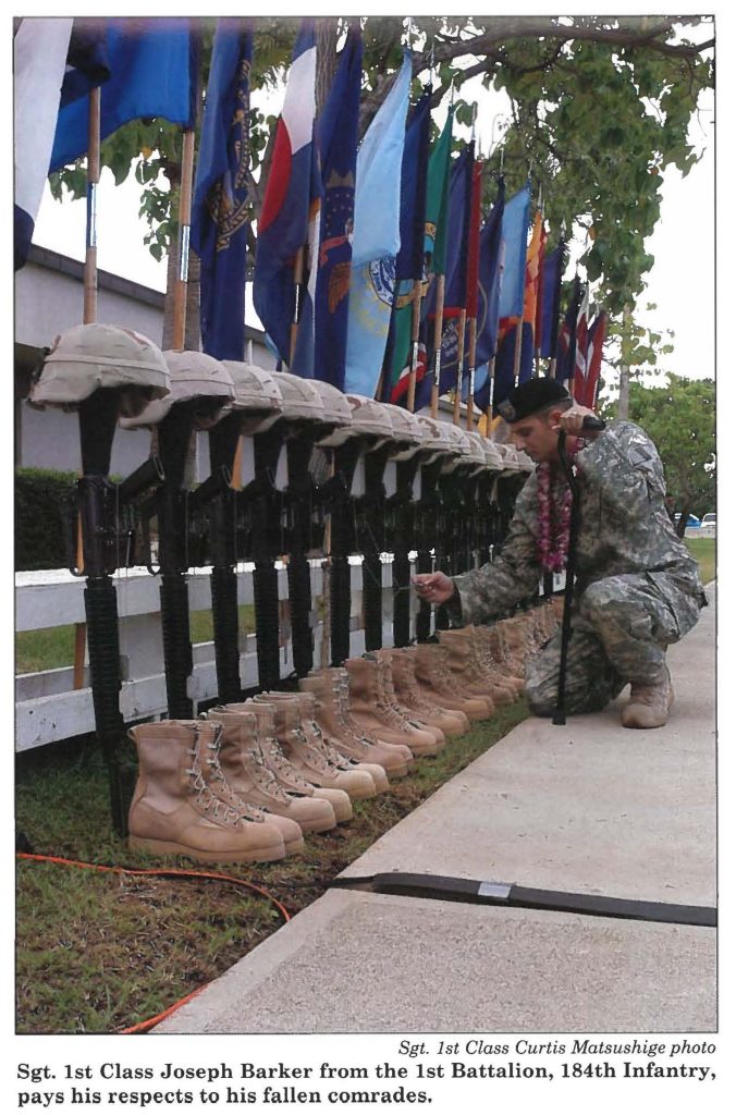 Sgt. 1st Class Joseph Barker from the 1st Battalion, 184th Infantry, pays his respects to his fallen comrades.