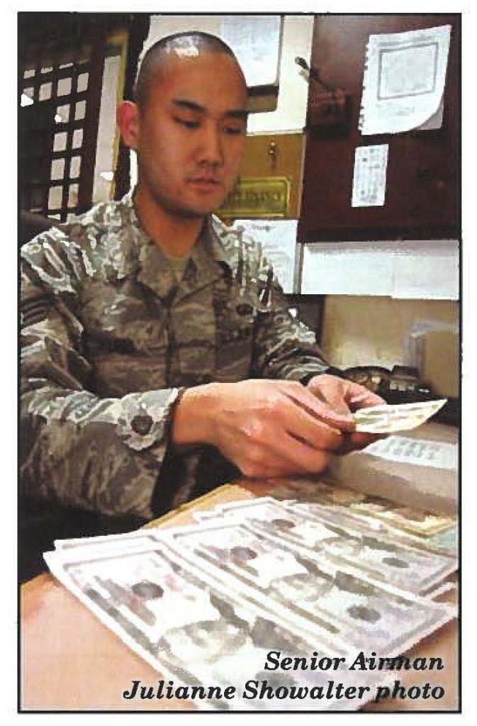 BALAD AIR BASE, Iraq-Senior Airman Ryan Yung, financial manager, counts out money for a customer,