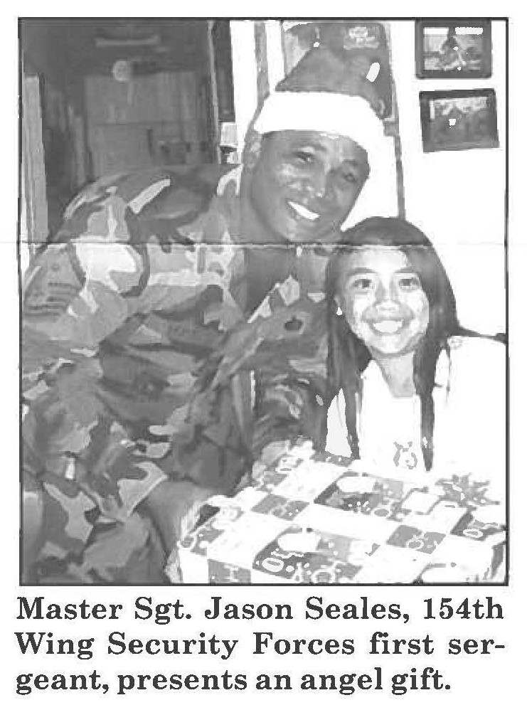 Master Sgt. Jason Seales, 154th Wing Security Forces first sergeant, presents an angel gift.