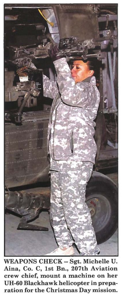WEAPONS CHECK - Sgt. Michelle U. Aina, Co. C, 1st Bn., 207th Aviation crew chief, mount a machine on her UH-60 Blackhawk helicopter in preparation for the Christmas Day mission.