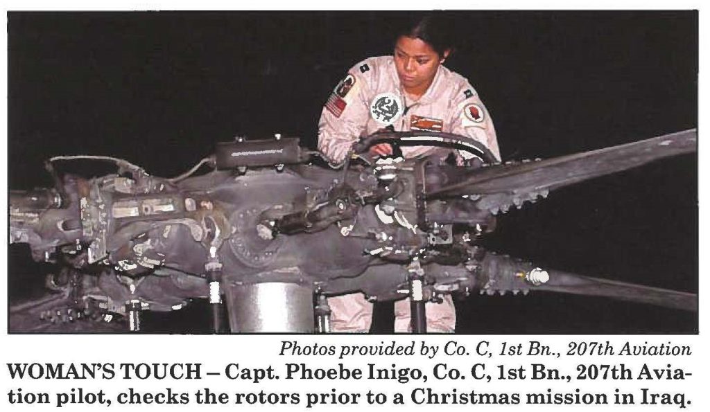 WOMAN'S TOUCH - Capt. Phoebe Inigo, Co. C, 1st Bn., 207th Aviation pilot, checks the rotors prior to a Christmas mission in Iraq.