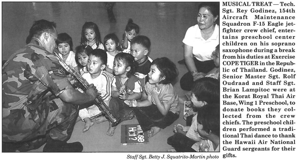 MUSICAL TREAT-Tech. Sgt. Rey Godinez, 154th Aircraft Maintenance Squadron F-15 Eagle jetfighter crew chief, entertains preschool center children on his soprano saxophone during a break from his duties at Exercise COPE TIGER in the Republic of Thailand. Godinez, Senior Master Sgt. Rolf Oudraad and Staff Sgt. Brian Lampitoc were at the Korat Royal Thai Air Base, Wing 1 Preschool, to donate books they collected from the crew chiefs. The preschool children performed a traditional Thai dance to thank the Hawaii Air National Guard sergeants for their gifts.