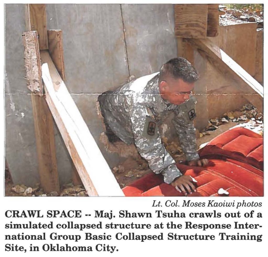 CRAWL SPACE -- Maj. Shawn Tsuha crawls out of a simulated collapsed structure at the Response International Group Basic Collapsed Structure Training Site, in Oklahoma City.