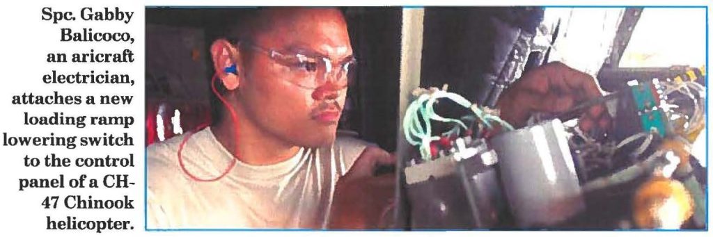 Spc. Gabby Balicoco, an aircraft electrician, attaches a new loading ramp lowering switch to the control panel of a CH47 Chinook helicopter.