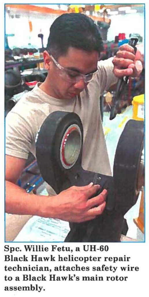 Spc. Willie Fetu, a UH-60 Black Hawk helicopter repair technician, attaches safety wire to a Black Hawk's main rotor assembly.