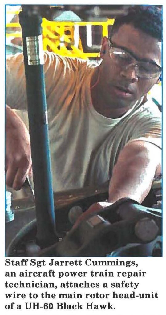 Staff Sgt Jarrett Cummings, an aircraft power train repair technician, attaches a safety wire to the main rotor head-unit of a UH-60 Black Hawk.