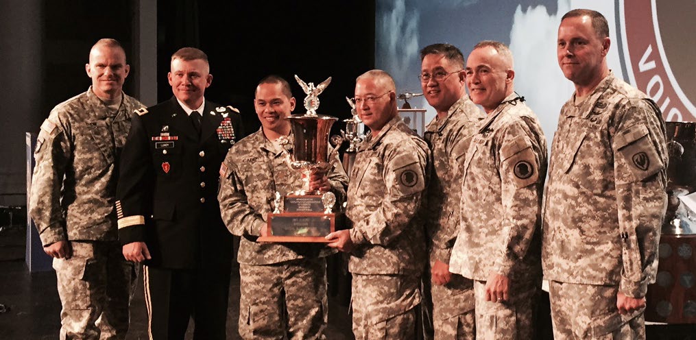 Holding the award for the Aviation Association of America for the year of 2014 are MAJ Byron N. Cadiz (L), former commander of 1-171, and First Sgt. Keith I. Nakahara, they are joined on-stage by Col. Roger Pukahi, State Army Aviation Officer and Brig. Gen. Oliveira, Commander of the Hawaii Army National Guard.