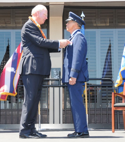 Maj. Gen. Darryll D.M. Wong, former Hawaii State adjutant general and retired Gen. Craig McKinley, former chief, National Guard Bureau, salute the Hawaii state flag during a retirement ceremony at the Distinguished Visitors reception area on Joint Base Pearl Harbor-Hickam, Hawaii, April 12, 2015. The Royal Guard, consisting of members of the Hawaii Air National Guard, present the colors for the ceremony. (U.S. Air Force photo by Airman 1st Class Robert Cabuco/Released)