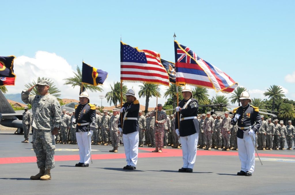 Maj. Gen. Darryll D.M. Wong, former Hawaii State adjutant general and retired Gen. Craig McKinley, former chief, National Guard Bureau, salute the Hawaii state flag during a retirement ceremony at the Distinguished Visitors reception area on Joint Base Pearl Harbor-Hickam, Hawaii, April 12, 2015. The Royal Guard, consisting of members of the Hawaii Air National Guard, present the colors for the ceremony. (U.S. Air Force photo by Airman 1st Class Robert Cabuco/Released)