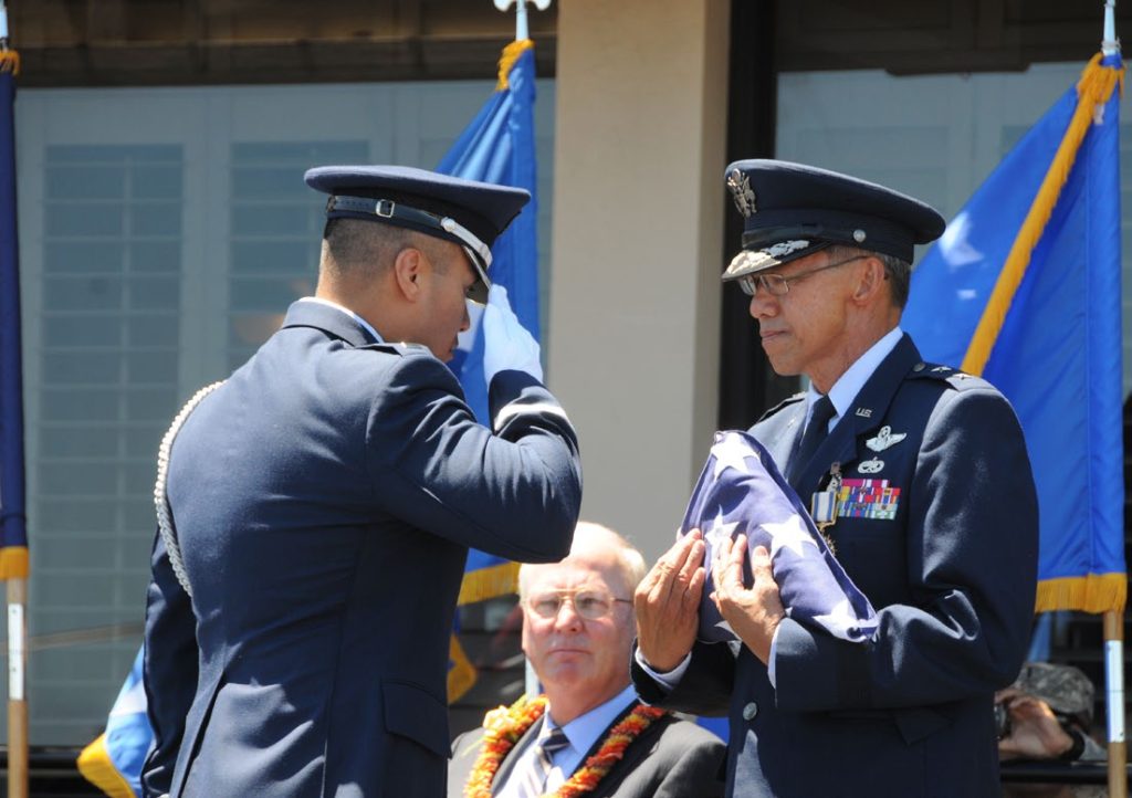 Maj. Gen. Darryll D.M. Wong, former Hawaii State adjutant general and retired Gen. Craig McKinley, former chief, National Guard Bureau, salute the Hawaii state flag during a retirement ceremony at the Distinguished Visitors reception area on Joint Base Pearl Harbor-Hickam, Hawaii, April 12, 2015. The Royal Guard, consisting of members of the Hawaii Air National Guard, present the colors for the ceremony. (U.S. Air Force photo by Airman 1st Class Robert Cabuco/Released)