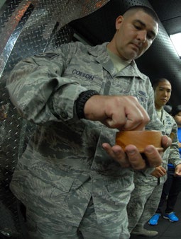 Salt is spread throughout the facility by the chaplain and members of the 154th SFS as a way to purify and protect the facility. (U.S. Air National Guard photo by Airman 1st Class Robert Cabuco)