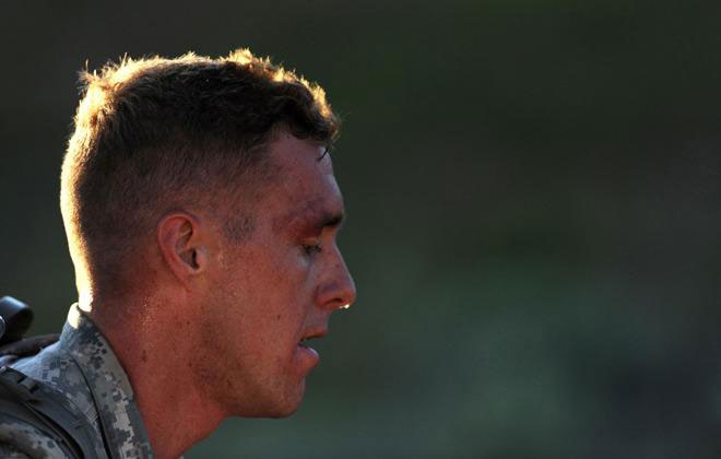 COURTESY ARMY SGT. 1ST CLASS JON SOUCY Spc. Cruser Barnes, a cavalry scout with the Hawaii Army National Guard, takes a breather during the 12-mile rucksack march event of the 2015 Army National Guard Best Warrior Competition at Camp Williams, Utah