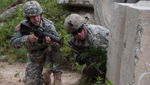 U.S. Army Spc. Cruser Barnes (center), 1st Squadron, 299th Cavalry Regiment, Hawaii Army National Guard, takes a knee behind cover with Spc. Jared Okimoto, 777th Aviation Support Battalion, HIARNG, during a movement under direct fire exercise as part of the 2015 Hawaii Army National Guard and Reserve Best Warrior Competition March 8, 2015, at Marine Corps Training Area Bellows, Hawaii. (U.S. Air Force photo by Staff Sgt. Christopher Hubenthal)