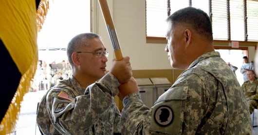 Brig. Gen. Keith Y. Tamashiro, commander of the Hawaii Army National Guard, passes the 103rd Troop Command guidon to the new commander of the unit, Col. Roger Pukahi during the 103rd Troop Command’s change of command ceremony at the Hawaii Army National Guard armory Oct. 3, 2015. Pukahi assumed command from Col. Robert W. Lesher. (U.S. Army National Guard photo by Pfc. Paul D. Berzinas /Released)