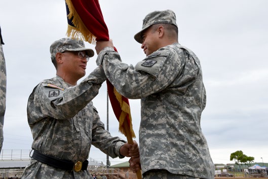 Brig. Gen. Keith Y. Tamashiro passes the 29th Infantry Brigade Combat Team Guidon to Col. Moses Kaoiwi, Jr. during the 29th Infantry Brigade Combat Team change of command ceremony in Kapolei, Hawaii, Oct. 4, 2015. The ceremony was attended by many distinguished guests, including Gov. David Ige. (U.S. Army National Guard photo by Pfc. Paul D. Berzinas/ Released)