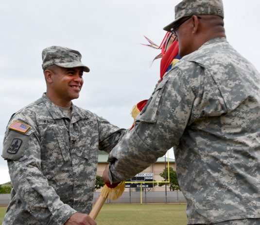 Col. Moses Kaoiwi, Jr. passes the 29th Infantry Brigade Combat Team guidon to his senior enlisted advisor during the 29th Infantry Brigade Combat Team change of command ceremony in Kapolei, Hawaii, Oct. 4, 2015. Kaoiwi assumed command from Col. Stephen F. Logan. (U.S. Army National Guard photo by Pfc. Paul D. Berzinas/Released)
