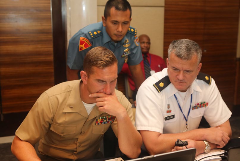 U.S. Marine Corps 1st Lt. Nicholas J. Boire, left, reviews the execution plan during a simulated search and rescue mission as part of Exercise Gema Bhakti in Jakarta, Indonesia, Sept. 17, 2015, as instructors U.S. Army Major Bill Flynn, right, and Indonesian Marine Corps Major Nyoman provide feedback. The urban search and rescue training is one of four lanes that increases service members’ humanitarian assistance and disaster response capabilities in the Pacific area of operations which is prone to various natural disasters. Gema Bhakti, Indonesian for ‘Echo of Good Deeds,’ is a joint, bilateral ten-day exercise designed to promote positive military relations, increase cultural awareness and enhance training and understanding of each other’s capabilities. Boire, a native of New York, New York, is the combined anti-armor platoon commander with weapons company, 1st Battalion, 4th Marine Regiment and currently deployed to Darwin, Australia, as part of Marine Rotational Forces-Darwin. Flynn, a native of Orlando, Florida, is the acting commander for chemical, biological, radiological and nuclear enhanced response force package (CERFP) with the Hawaii National Guard. Nyoman, a native of Jakarta, Indonesia, is an operations officer with 2nd Engineer Battalion and a past participant of Operation Cobra Gold, a Pacific Command directed multinational and multiservice exercise. (U.S. Marine Corps photo by 2nd Lt. Michael Maggitti/Released)