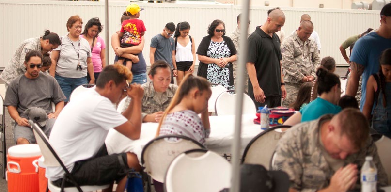 U.S. Air Force airmen and families from the Hawaii Air National Guard’s 154th Security Forces Squadron, observe grace before lunch during a family day event on Joint Base Pearl Harbor-Hickam, Hawaii on Aug. 7, 2016. The 154th SFS has one of the highest deployment rates in the HIANG. (U.S. Air National Guard photo by Airman 1st Class Stan Pak/released)