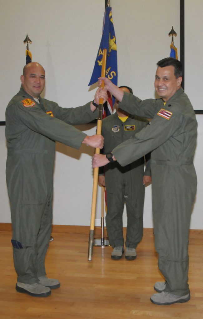 U.S. Air Force Lt. Col. Damon L. Pescaia, (then) commander of the 154th Operations Group, passes the 204th Airlift Squadron guidon to Lt. Col. Robert T. Chowhoy, new commander of the 204th AS during an assumption of command ceremony at Joint Base Pearl HarborHickam, Jan. 9, 2016. The exchange of the unit colors is a tradition symbolizing the acceptance or transfer of command. (U.S. Air National Guard photo by Airman 1st Class Robert Cabuco/released)