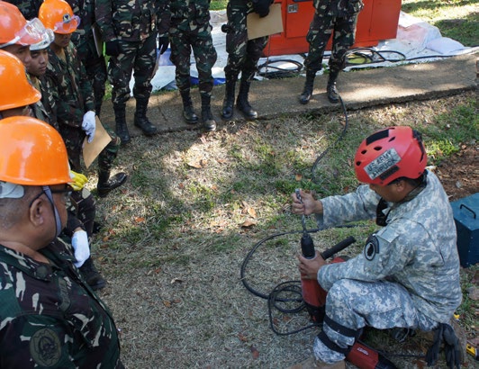 Staff Sgt. Ryan Ahpuck with the Hawaii National Guard CERFP breaching and breaking team demonstrates changing a bit on a hammer drill for the Armed Forces Philippines for Balikatan 2016, April 09, 2016, Camp Capinpin, Philippines.