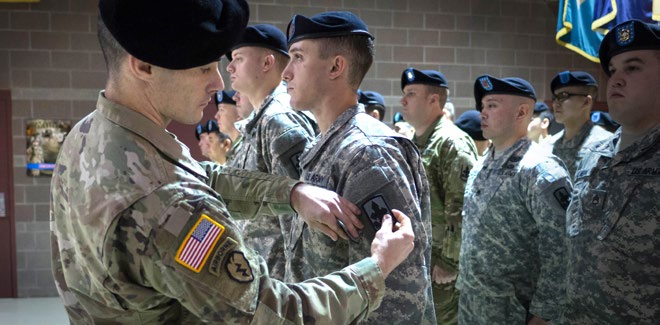 First Lt. James Tollefson, commander of A Company, 1st Battalion, 297th Infantry Regiment, affixes the 29th Infantry Brigade Combat team patch to mortarman Spc. Drew Gatlin, Oct. 16, 2016, at the Alaska National Guard Armory at Joint Base Elmendorf-Richardson. The 1-297th Infantry activated during the ceremony and became a subordinate unit to 29th IBCT, Hawaii Army National Guard.