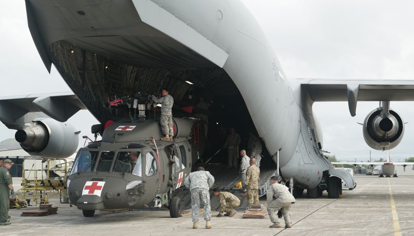 Aircrew members from the Tennessee Air National Guard and Hawaii Army National Guard Soldiers off load the first of three HH-60M Blackhawk Helicopters from a C-17 at Kalaeloa Airfield. The HH-60M Blackhawks are being assembled on site and will operate out of Wheeler Army Airfield until the 189th Aviation Regiment’s facilities are completed at Kalaeloa, Oct 28, 2016 (U.S. Air National Guard Photo By Tech. Sgt. Andrew Jackson)