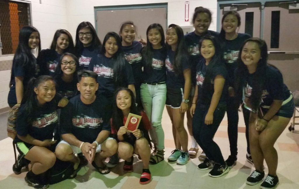 TEAM EFFORT – Coach Greg Lum Ho poses with his Kea’au High School girls’ basketball team.