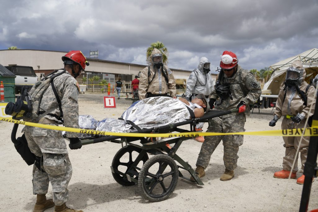Members the Hawaii National Guard’s search and extraction team deliver a disaster victim to the recitation area for decontamination and medical treatment during the Combined Training Exercise at Kalaeloa, Hawaii, July 17, 2017. A CTE is biannual training event that affords CERFP team members opportunities to grow in their disaster response skills. (Air National Guard Photo by Tech. Sgt. Andrew Jackson)
