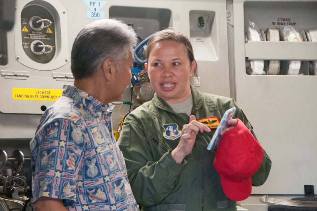 Hawaii Air National Guard Master Sgt. Kerrie Morris, a loadmaster from the 204th Airlift Squadron, shows David Ige, State of Hawaii Governor, imagery from a Hurricane Harvey relief mission at Joint Base Pearl Harbor-Hickam, Hawaii on Sep. 10, 2017. The mission involved the tactical airdrop of generators, a mobile hospital and an ambulance among a long list of relief supplies. (U.S. Air National Guard photo by Senior Airman Robert Cabuco)