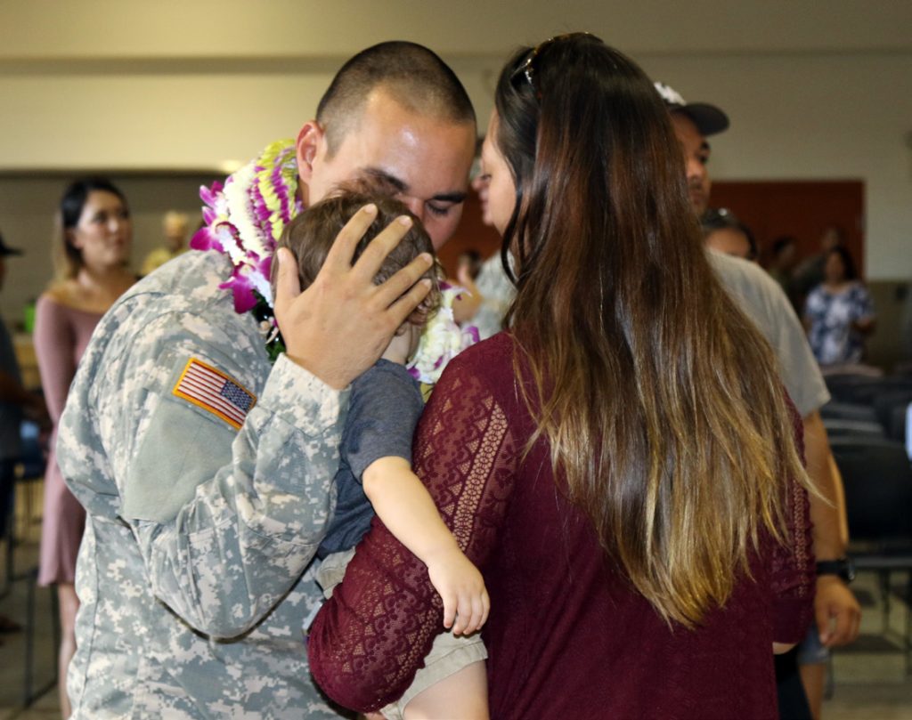 A Soldier from the 297th Engineer Detachment Fire Fighting Team embraces loved ones during the deployment ceremony at the 103rd Troop Command Armory in Pearl City, Hawaii on July 18, 2017. The Fire Fighting Team’s mission is to provide fire protection for aviation assets and major facilities in any theater of operations. (U.S. Army National Guard photo by Spc. Lisa K. Lariscy)