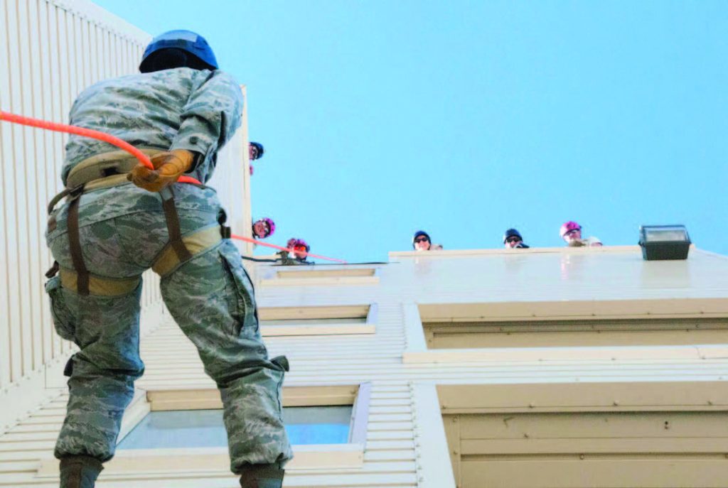 An airman rappels down a building while team members look on from above during search and extraction training as part of a Medical Capabilities exercise conducted Jan. 28, 2018 in North Las Vegas. During the exercise Air National Guard medical units from Hawaii, California, and Nevada practiced the skills and procedures needed during a coordinated emergency response involving the FEMA Region 9 partners. (U.S. Air National Guard photo by Senior Airman Orlando Corpuz)