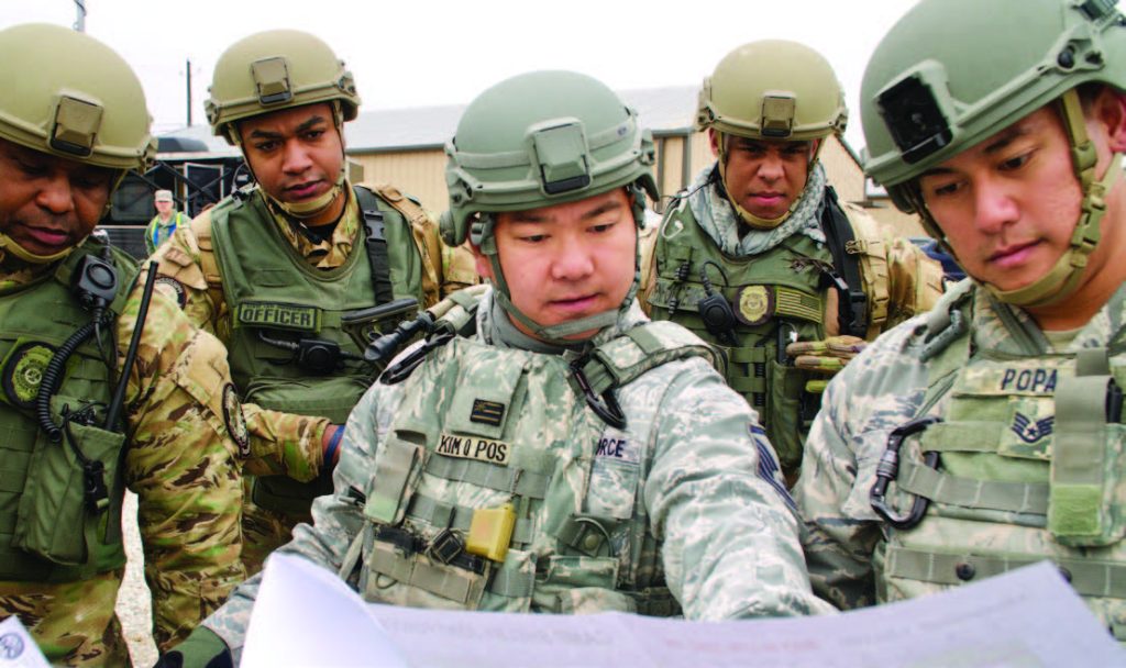 Master Sgt. Robert Kim, Vice Troop Commander for Patriot South exercise, looks over a map of their training grounds with the Mississippi Department of Wildlife, Fisheries and Parks Special Response Team to plan their next steps for the exercise, Feb. 13, 2018, at Camp Shelby, Mississippi. Patriot South focuses on increasing the understanding of coordination, policies, and procedures required in conducting a Joint-Inter-Agency Domestic response. (U.S. Air National Guard photo by Staff Sgt. James Ro)