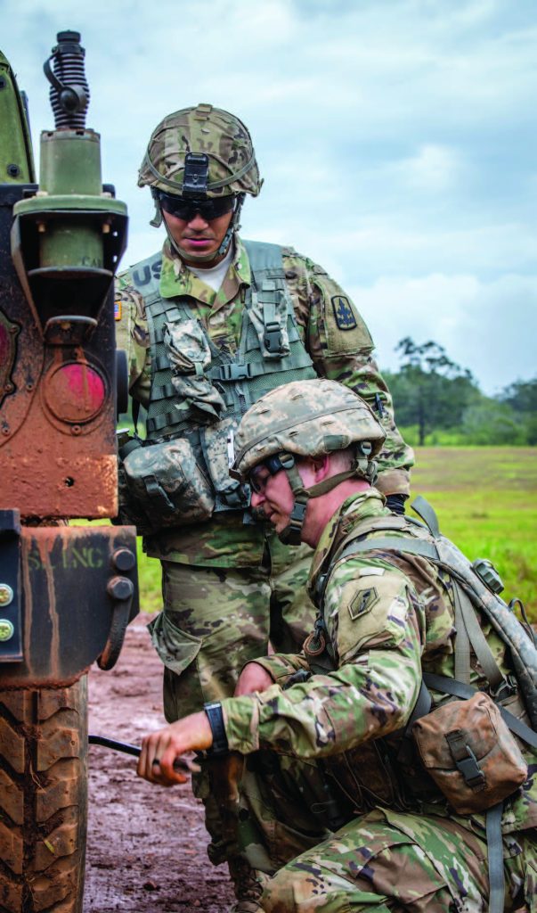 Sgt. William A. Chea of 1st platoon, Bravo Troop, 1st Squadron, 299th Cavalry Regiment watches Sgt. David C. Westman of the Headquarters and Headquarters Company, 100th Battalion, 442nd Infantry Regiment change a tire during the Best Warrior Competition at Schofield Barracks, Hawaii Mar. 3, 2018. (U.S. Army National Guard Photo by Sgt. Amanda Gerlach)