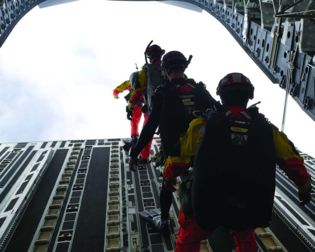 New York Air National Guard Airmen from the 103rd Rescue Squadron step toward the rear of a C-17 during an astronaut recovery training scenario March 4, 2018, off the coast of Oahu, Hawaii. This is the second consecutive year the New York Airmen trained with the Hawaii Air National Guard’s 204th Airlift Squadron to improve their search and rescue capabilities. (U.S. Air National Guard photo by Senior Airman John Linzmeier)
