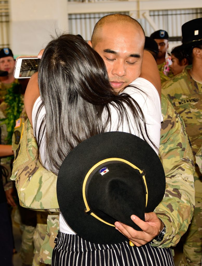 Sgt. 1st. Class Lesley R. Pasion, Cavalry Scout with Alpha Troop, 1st Squadron, 299th Cavalry Regiment, Hawaii Army National Guard hugs his family member after his deployment ceremony at the Kalaeloa Army Aviation Support Facility on August 26, 2018. The 1-299th CAV will be deploying to Sinai, Egypt supporting the Multinational Force and Observers while the 29th IBCT will be deploying to Kosovo in support of Multinational Battle Group East Kosovo Forces (KFOR). (U.S. Army National Guard photo by Sgt. 1st Class Theresa Gualdarama)