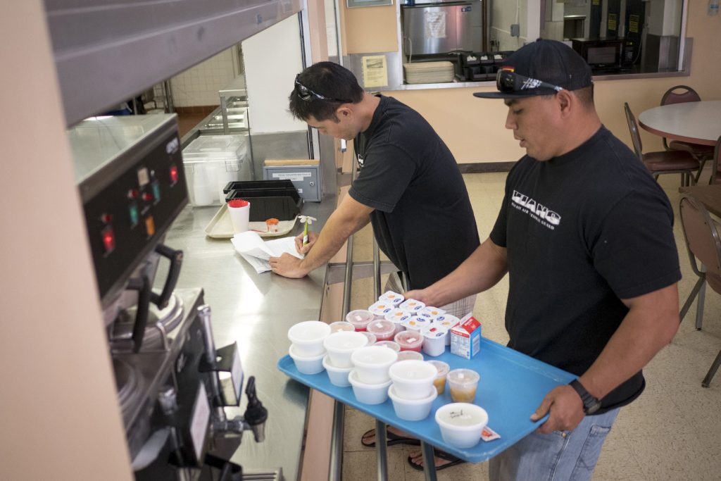 Tech. Sgt. Randall Kobayashi and Staff Sgt. John Quijano, from the Hawaii Air National Guard’s 154th Logistics Squadron, pick up meals Dec. 17, 2018, at retirement home in Kalihi, Hawaii. The Airmen have been delivering free meals to people who are burdened with physical challenges as part of a meals-on-wheels program. (U.S. Air National Guard photo by Senior Airman John Linzmeier)